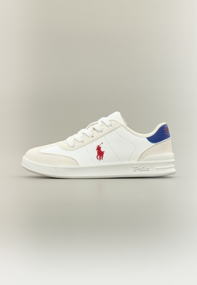 Λευκό sneaker χαμηλού ύψους με μπεζ λεπτομέρειες, κόκκινο λογότυπο Polo στο πλάι, μπλε ταμπέλα στη φτέρνα και το «Polo» να είναι ανάγλυφο στη λευκή σόλα.