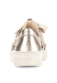 Metallic silver rear of a sneaker with a textured white sole and large fabric bow on the back, featuring a smooth upper and padded ankle.