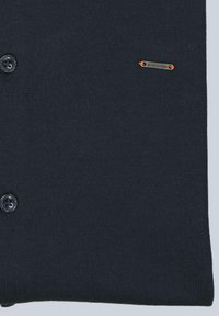 Marineblaue Strickjacke mit sechs Knöpfen, die eine subtile Textur und ein kleines Metall-Logo-Tag mit orangen Akzenten auf der Vorderseite aufweist.