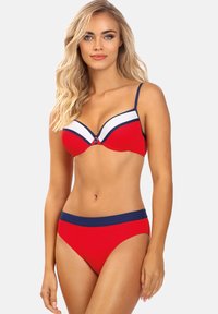 Czerwony bikini z kontrastującym granatowym pasem, z wzorzystym białym wstawką na górze. Regulowane ramiączka i akcent guzika na środku.