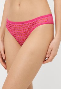 Rosa Mesh-Bikini-Höschen mit runden Ausschnitten, elastischem Bund und glatten Kanten, konzipiert für Atmungsaktivität und Komfort.