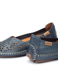 Dunkelblaue Lederschuhe mit durchbrochenen Blumenmustern, kontrastierenden Steppnähten, strukturierten Akzenten und einem Markenetikett, ausgestattet mit einem low-profile Design.