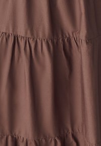 Brown fabric featuring a tiered design with ruffled seams, smooth texture, and subtle sheen, suitable for various clothing items.
