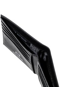Portafoglio in pelle nera con più scomparti per carte, una superficie liscia e una fodera in tessuto con un'etichetta con il logo che recita "Armani Exchange."