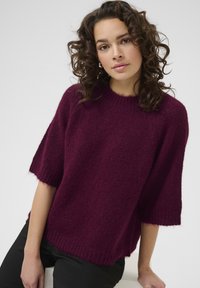 Maglione lavorato a maglia bordeaux con maniche corte, collo rotondo e orlo a coste. Tessuto morbido con una vestibilità ampia, che mette in risalto un design casual.