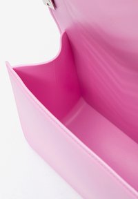 Interno di una borsa rosa che mostra un comparto liscio e vuoto con bordi puliti, progettato per riporre oggetti personali.