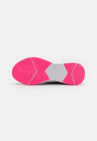 Sneaker met een witte bovenkant en een roze trekzool. Heeft een zigzagpatroon op de zool en een hexagonale middensectie. Van rubbermateriaal.