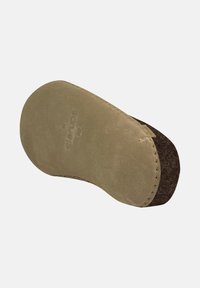 Semelle d'une chaussure en suédine beige clair avec un doublure en feutre marron. Forme contournée avec des détails de couture le long du bord. Logo embossé sur la surface.