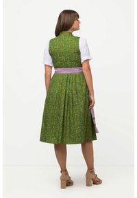 Groene bloemenjurk met een aansluitend lijfje, korte witte mouwen en een lila tailleband; A-lijn rok van textuurstof met een kleurrijk patroon.