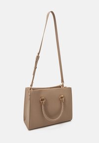 Sac à main beige avec une forme structurée, en matériau synthétique texturé, anse supérieure tressée et quincaillerie dorée. Bretelle réglable incluse.