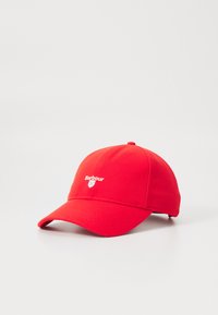 Punane pesapalli müts, mis on valmistatud kangast, esiosas valge logo, kumer visor, reguleeritav rihm taga ja sile tekstuur.