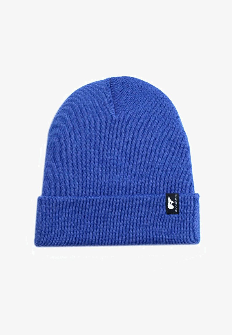 Bonnet en tricot bleu royal avec un revers, fabriqué en matière acrylique douce. Présente une petite étiquette logo noire sur le côté.