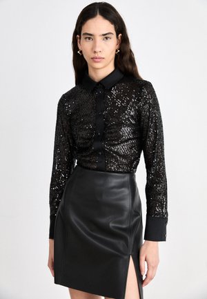 Black sequined shirt with a collar and front buttons, paired with a black leather skirt featuring a side slit. Smooth texture, shiny accents.
