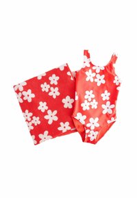 Röd baddräkt med vitt blommönster tillsammans med en matchande röd handduk med vita blommor, båda gjorda av mjuka och släta material.