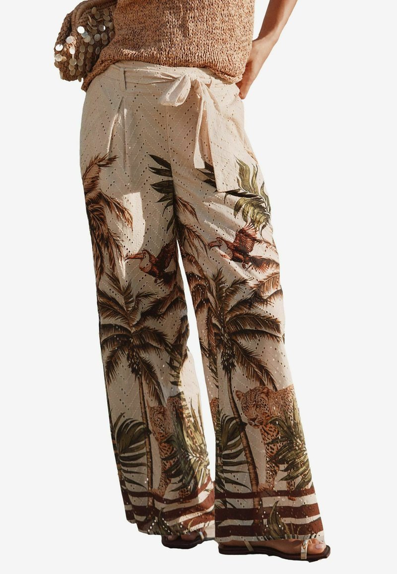 Pantaloni a gamba larga realizzati in tessuto leggero, con una base beige e stampe di palme e leopardi. Fiocco in vita e texture perforata.