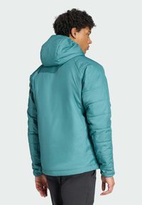 Türkiser gepolsterter Parka mit Kapuze, ausgestattet mit gesteppten Ärmeln und glatter Textur. Die Rückseite weist ein klares Design und elastische Bündchen auf.