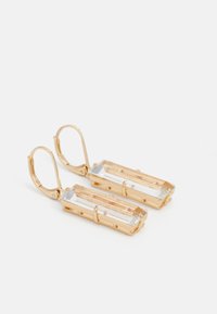 Boucles d'oreilles en ton doré présentant des cristaux rectangulaires transparents dans un cadre en métal, avec une fermeture à crochet et une surface texturée.