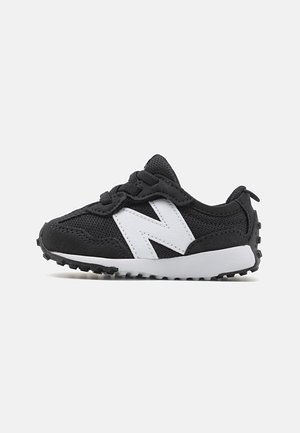 Zwarte peutersneaker met mesh- en suède textuur, witte zool, wit zijlogo en veters, in profiel getoond tegen een egale achtergrond.