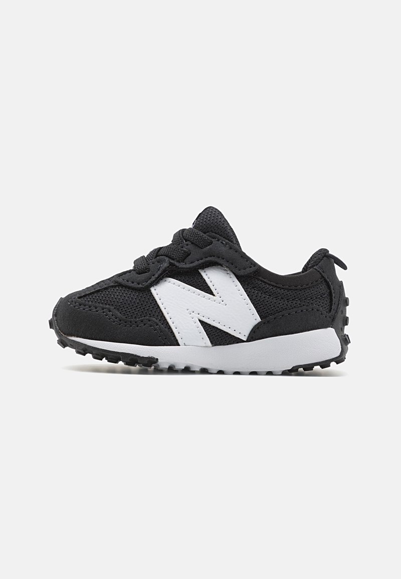 Baskets noires pour tout-petit avec texture en mesh et en daim, semelle blanche, logo latéral blanc et lacets, présentées de profil sur un fond uni.