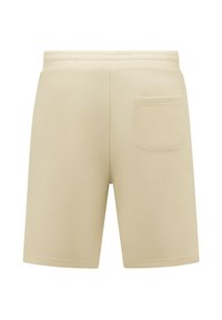 Beige katoenen shorts met een zachte textuur, elastische tailleband en één enkele achterzak. Rechte snit zonder zichtbare patronen.