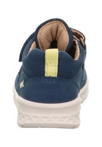 Blauer Sneaker mit einem weichen, strukturierten Lederobermaterial, gepolsterter Kragen, hellgelbem Zugband und weißer Gummisohle mit geometrischem Muster.