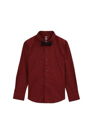 Piros, hosszú ujjas, gombos ing fehér pöttyökkel és fekete csokornyakkendővel a gallérnál. Simább textúra, klasszikus szabás, és letisztult dizájn.