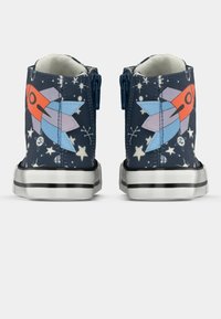 Παπούτσια από καμβά με ψηλό κορδόνι σε ναυτικό μπλε με εκτύπωση πυραύλου και αστεριού· διαθέτουν φερμουάρ, λευκές σόλες με μαύρες ρίγες και υφασμάτινη επάνω επιφάνεια.
