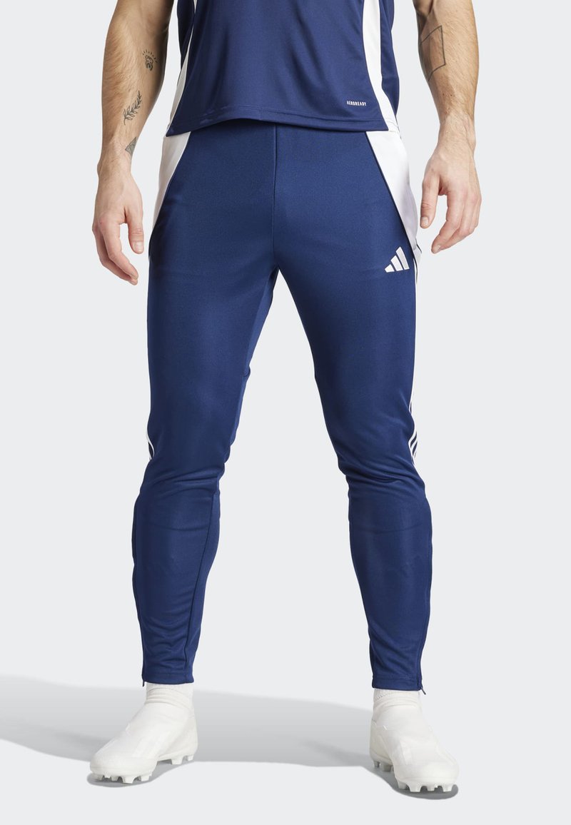 Marineblauwe sportbroek met witte zijaccenten en een Adidas-logo. Gemaakt van soepel, elastisch materiaal, ontworpen voor actieve beweging.