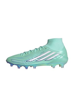 Chaussure de football bleu-vert clair avec chaussette à la cheville, bandes blanches sur le côté et semelle à crampons irisée.
