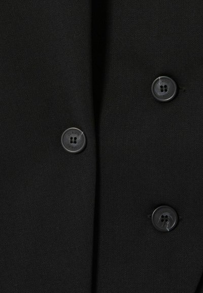 Tessuto nero con una texture liscia, caratterizzato da tre bottoni neri e dettagli di cucitura sottili lungo la patta.