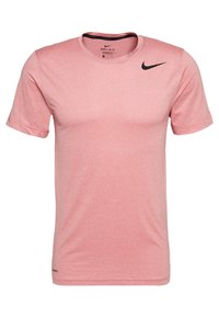 Vaaleanpunainen lyhythihainen T-paita, joka on valmistettu hengittävästä kankaasta ja jossa on musta Nike-logo vasemmalla rinnalla. Klassinen pyöreä pääntie ja pehmeä materiaalituntuma.