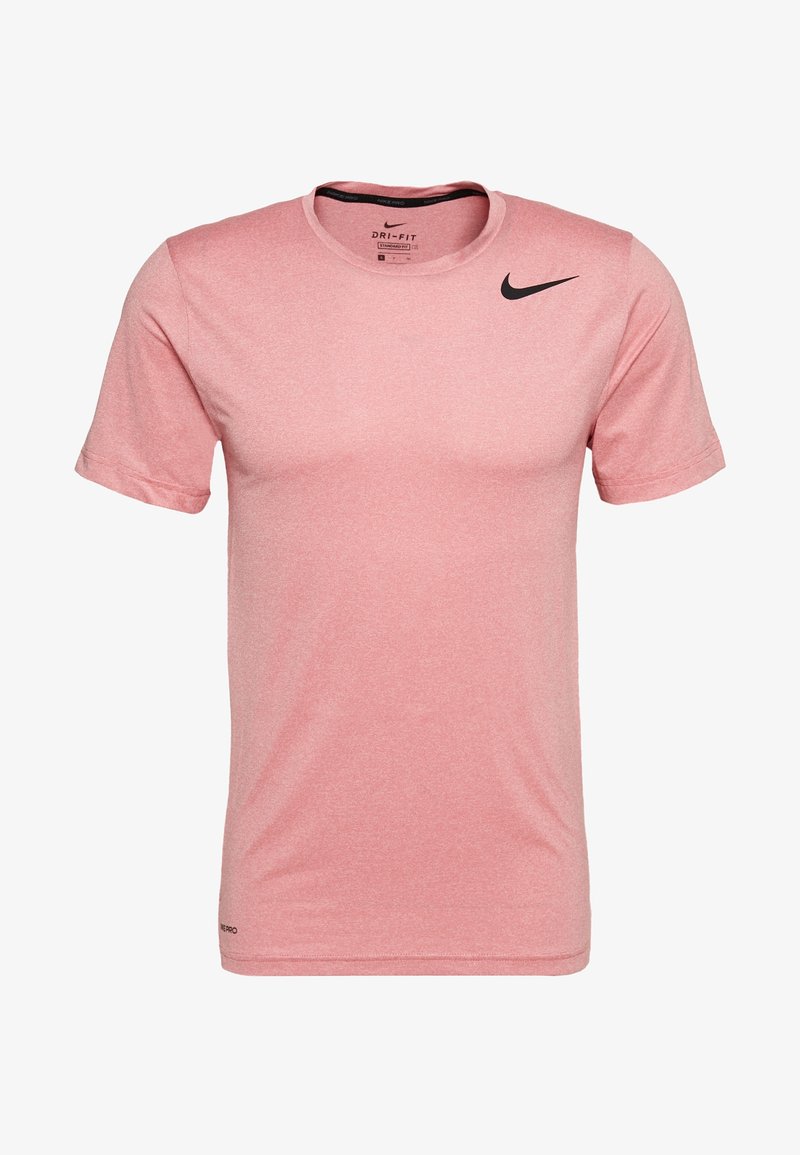 Vaaleanpunainen lyhythihainen T-paita, joka on valmistettu hengittävästä kankaasta ja jossa on musta Nike-logo vasemmalla rinnalla. Klassinen pyöreä pääntie ja pehmeä materiaalituntuma.