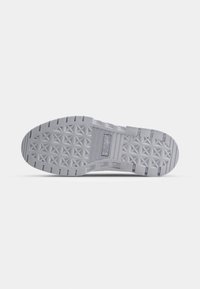 Semelle de chaussure plate grise avec motif de bande de roulement géométrique et logo Puma au centre, présentée sur fond blanc.