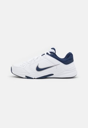 Biało-granatowy sneaker Nike z zapięciem na sznurówki i amortyzowaną podeszwą, pokazany z profilu na jasnym, jednolitym tle.
