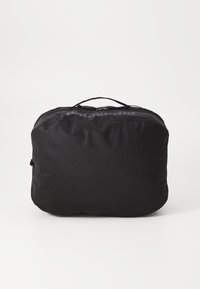 Svart reiseveske med en glatt, strukturert overflate. Rektangulær form, med et håndtak på toppen og glidelås. Logo trykt på siden.