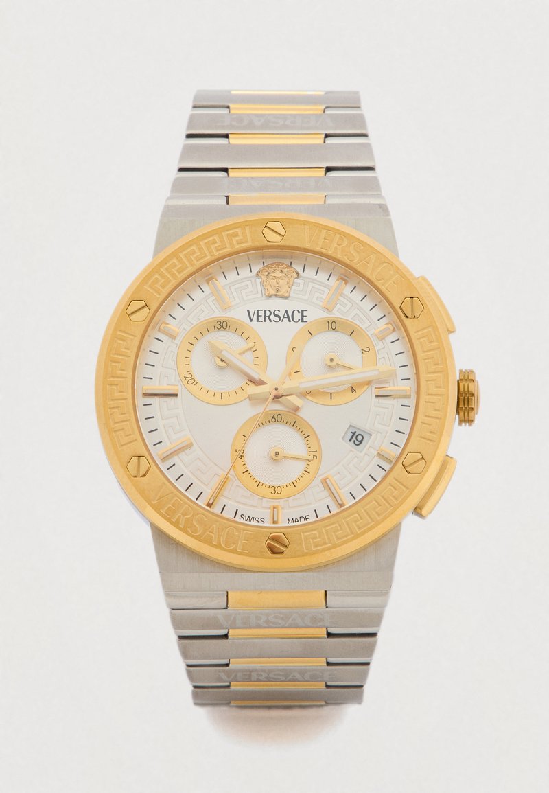 Ρολόι χρονογράφου Versace με στεφάνι σε χρυσό τόνο, λευκό καντράν με χρυσές λεπτομέρειες, μπρασελέ από ανοξείδωτο ατσάλι και περίπλοκο σχέδιο ελληνικού κλειδιού.