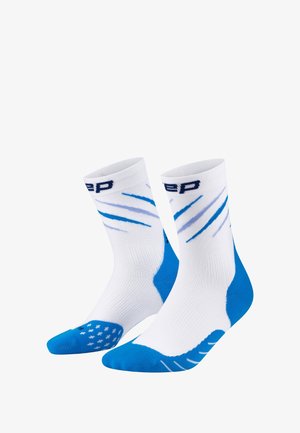 White athletic socks with blue accents, featuring a textured grip pattern on the sole, ribbed upper, and dynamic striped design.