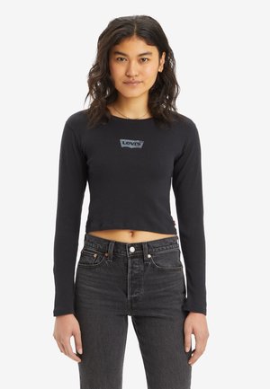 Black cropped long-sleeve t-shirt with a round neckline, featuring a blue Levi's logo centered on the chest and worn with black high-waisted jeans.