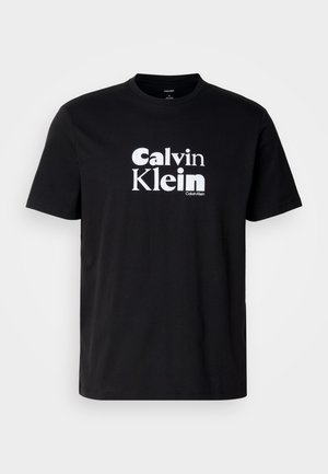Melna kokvilnas T-kreklu ar izteiktu baltu "Calvin Klein" logo, ar apaļu kaklu, īsām piedurknēm un standarta piegriezumu.