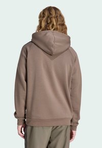 Hnedá mikina s kontrastnou kapucňou, ribkovanými manžetami a lemom. Hladká textúra, voľný strih a detaily na zadnom šve. Štandardná dĺžka.