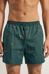 Pantalones de baño verdes hechos de un tejido ligero, con bordado de una rodaja de sandía roja, cintura elástica con cordón y un corte relajado.