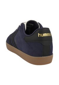 Navy blue suede shoe with black accents, a gum rubber sole, and gold logo. Features three black diagonal stripes on the side.