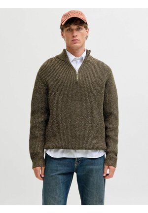 Grüner Strickpullover in Oliv mit hohem Kragen, halbem Reißverschluss und gerippten Bündchen, über einem gestreiften weißen Hemd getragen.