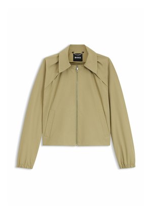 Veste marron clair zippée avec un col pointu, des manches longues avec des poignets élastiques et deux poches avant, étiquetée "BOSS" à l'intérieur.