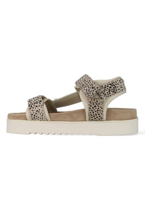Beige sandaal met zwarte gevlekte riemen, verstelbare klittenband sluitingen, gevoerde binnenzool en witte geribbelde plateauzool.