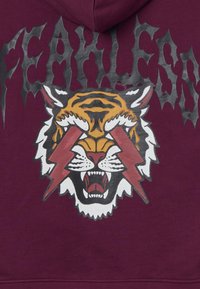 Bordeauxfarbener Hoodie mit einem auffälligen Grafikdruck eines brüllenden Tigers und roten Blitzen, auf einem weichen Baumwollmischgewebe gedruckt.