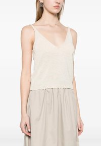 Top a maglia beige chiaro con spalline sottili, scollatura a V e orlo a coste, abbinato a una gonna fluida beige.