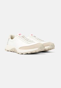 Sneaker leggere con una parte superiore in tela bianca e accenti in suede beige, e una suola in gomma testurizzata. Design con lacci e branding rosso.