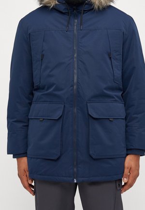 Parka aislante de color azul marino con capucha con borde de piel, cierre de cremallera en el frente y dos grandes bolsillos frontales. Presenta un exterior suave y resistente al agua.