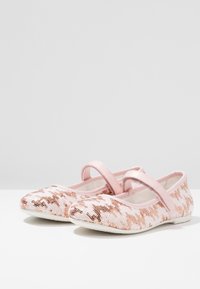 Różowe baletki z cekinami w wzór houndstooth, z paskiem na podbiciu oraz miękkim, zaokrąglonym noskiem.